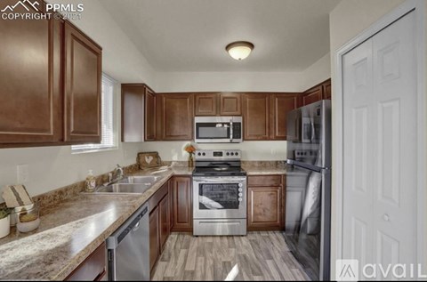 A kitchen with brown cabinets and a white door.