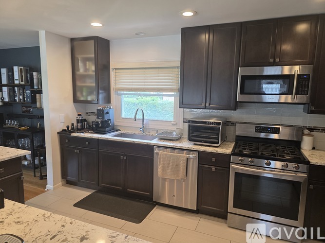 A kitchen with dark brown cabinets and stainless steel appliances.