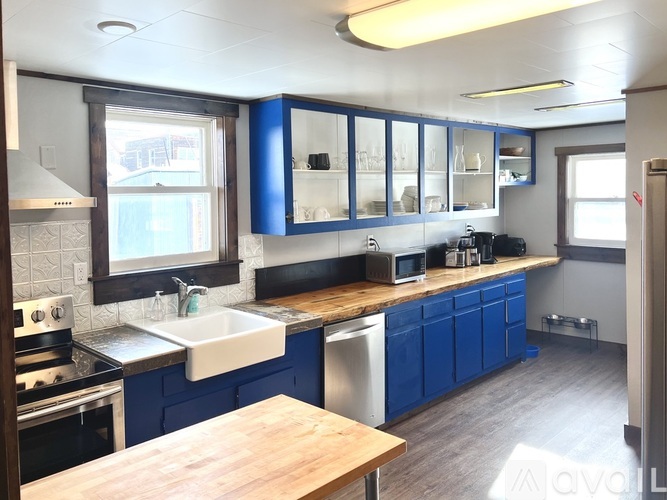 A kitchen with blue cabinets and a wooden island.