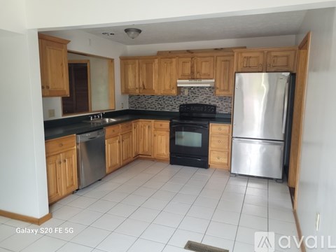 A kitchen with wooden cabinets and a black countertop.