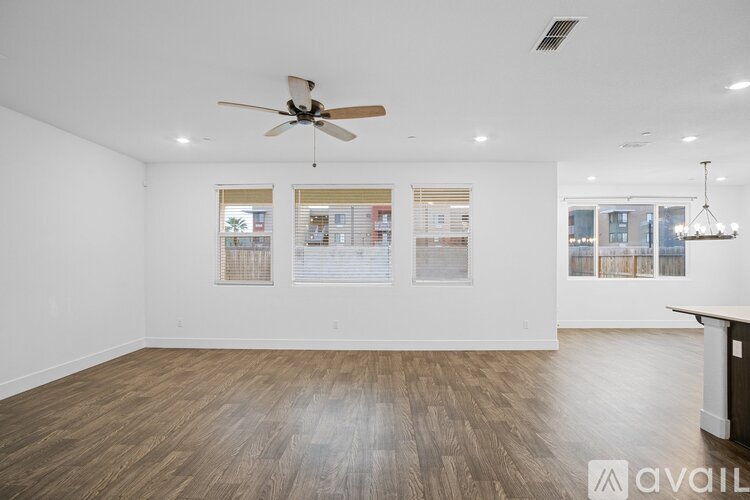 A spacious room with a ceiling fan and wooden flooring.