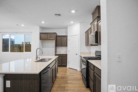 A modern kitchen with dark wood cabinets and a white countertop.