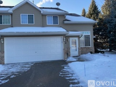A house with a garage and a driveway covered in snow.