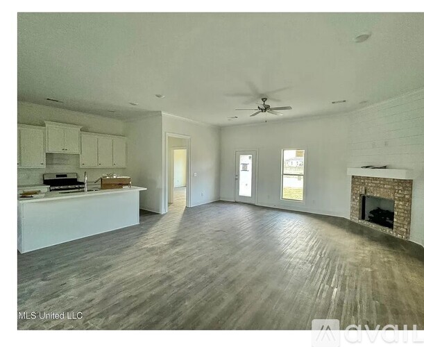 A spacious living room with a fireplace and hardwood floors.