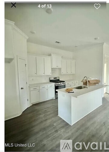 A kitchen with white cabinets and a wooden island.
