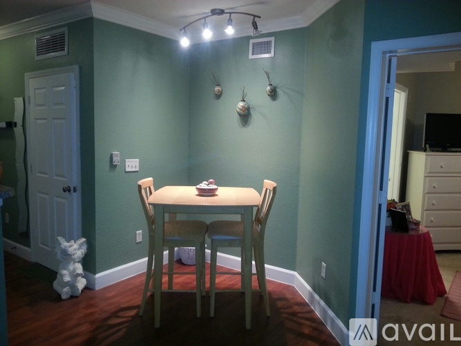 A dining room with a table and chairs.