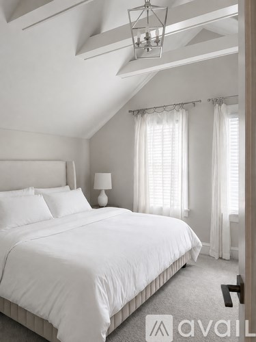 A bedroom with a large bed and a chandelier.
