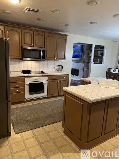 A kitchen with brown cabinets and a white oven.