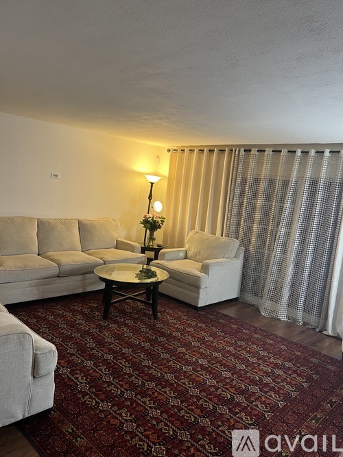A living room with a sofa, armchair, and a coffee table.