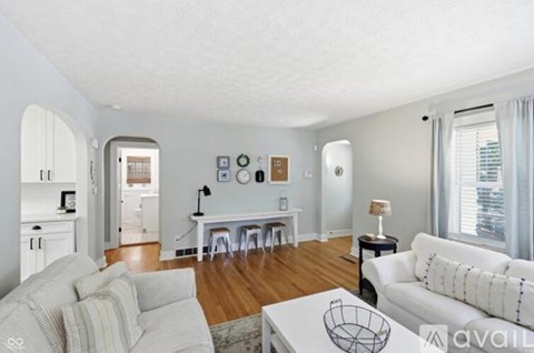 A living room with a white couch and a white coffee table.