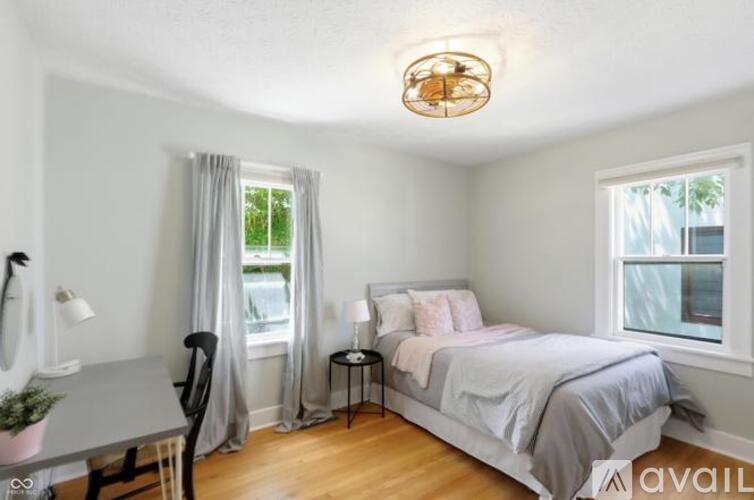 A bedroom with a bed, desk, and chair.