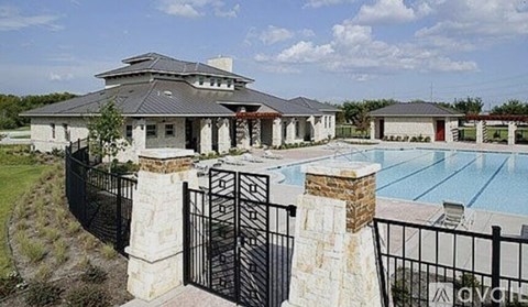 A large house with a pool and a gate.