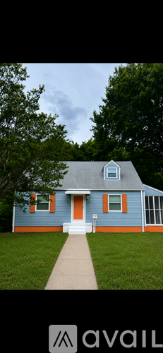 A blue house with a red door and a white porch.