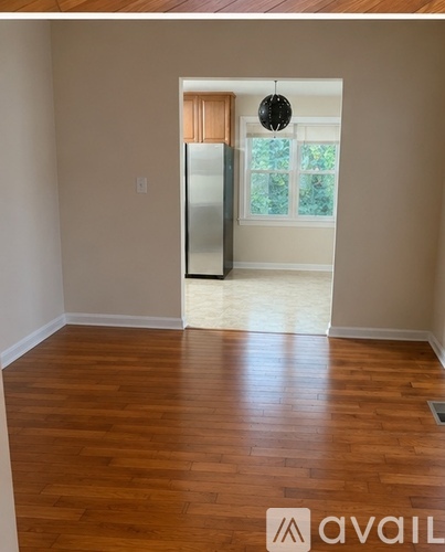 A room with wooden floors and a doorway leading to another room.
