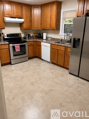 A kitchen with wooden cabinets and a tiled floor.