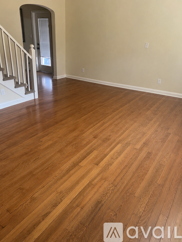 A room with wooden flooring and a staircase.