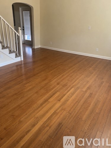 A room with wooden flooring and a staircase.