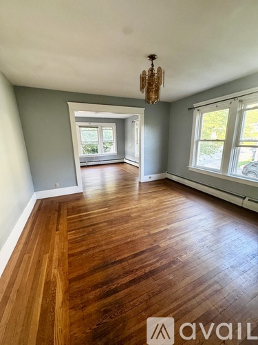 A room with wooden floors and a chandelier.