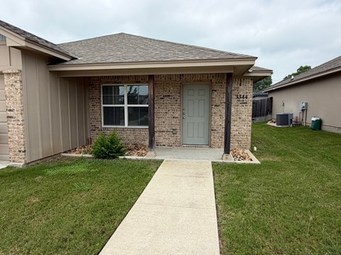 A house with a grey door and a grey garage door.