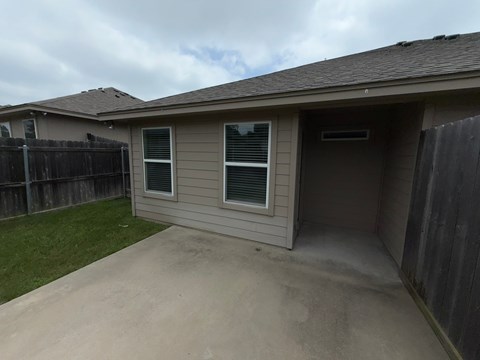 A house with a grey roof and a brown fence.