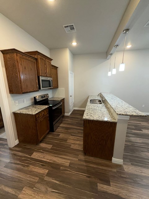 A kitchen with wooden cabinets and a granite countertop.