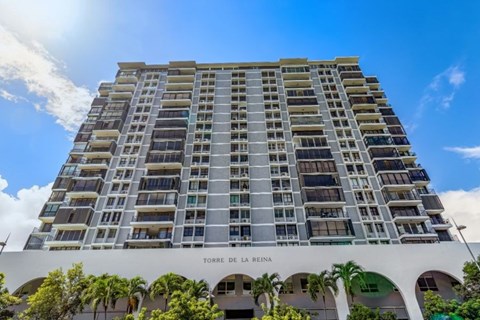 The building "TORRE DE LA REINA" is a tall residential building with many windows.