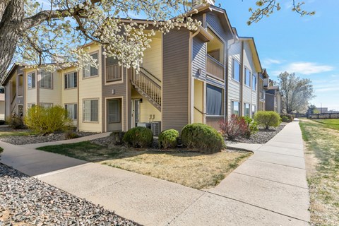 A row of townhouses with a sidewalk in front.