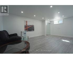 A living room with a couch, coffee table, and a picture of the Golden Gate Bridge on the wall.