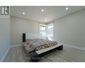 A bedroom with a bed, a window, and a speaker.