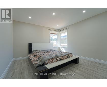A bedroom with a bed, a window, and a speaker.