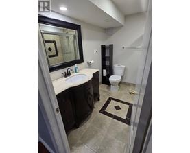 A bathroom with a sink, toilet and mirror.