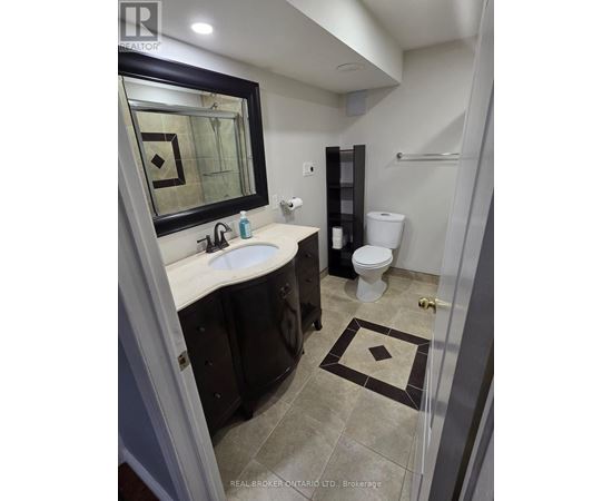 A bathroom with a sink, toilet and mirror.