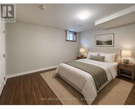 A bedroom with a bed, nightstands, and a framed picture on the wall.