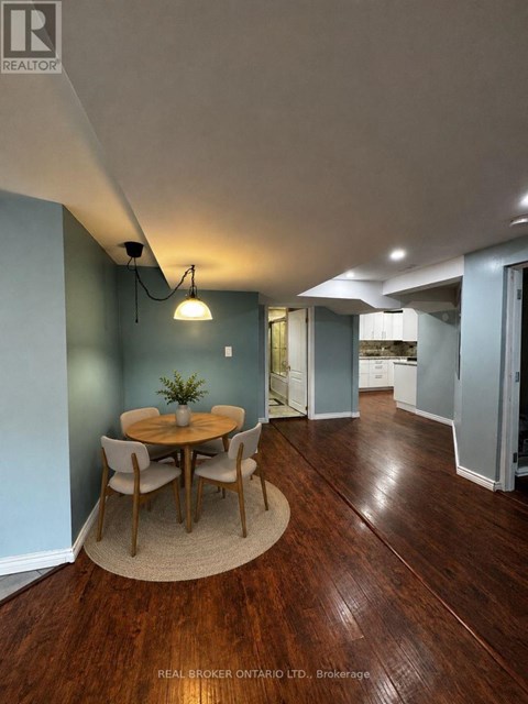 A dining room with a round table and chairs.