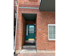 A red brick building with a green door and the number 418 on it.