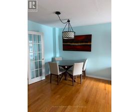 A dining room with a table and chairs.