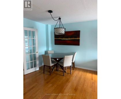 A dining room with a table and chairs.
