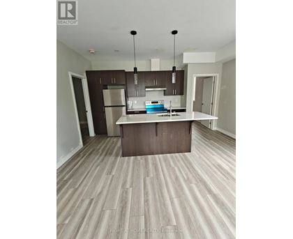 A modern kitchen with a central island and dark brown cabinets.