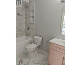A white toilet in a bathroom with marble tiles.