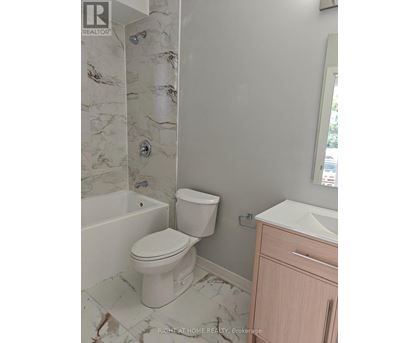 A white toilet in a bathroom with marble tiles.