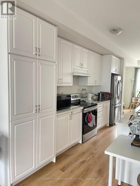 A kitchen with white cabinets and a black countertop.