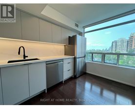 A kitchen with white cabinets and a black faucet.