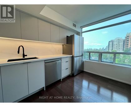 A kitchen with white cabinets and a black faucet.
