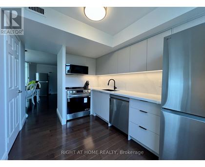 A kitchen with white cabinets and a stainless steel refrigerator.