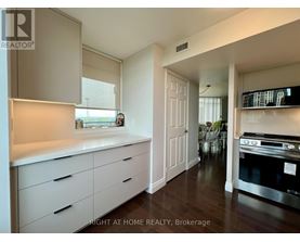 A kitchen with white cabinets and a stove top oven.