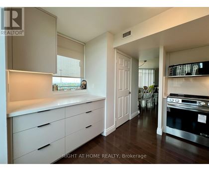 A kitchen with white cabinets and a stove top oven.