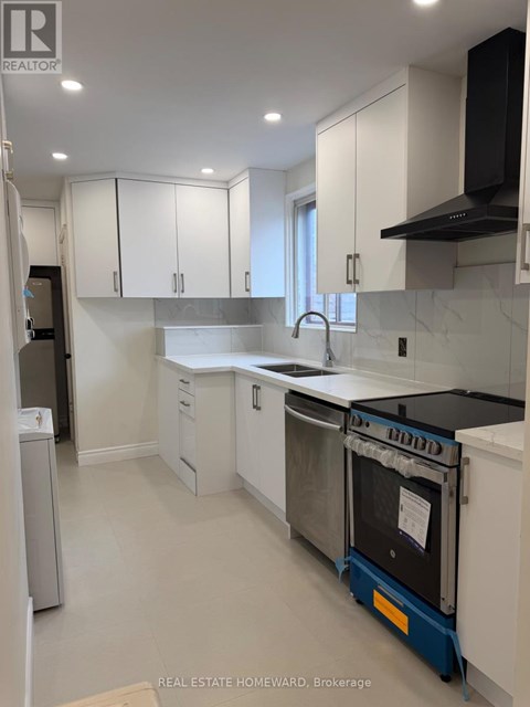 A kitchen with white cabinets and a black range hood.