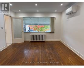 A room with wooden floors and a window with blinds.