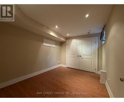 A room with wooden flooring and a white door.