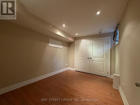 A room with wooden flooring and a white door.